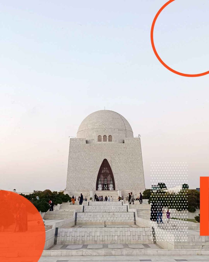 a large white building with a dome and a group of people with Mazar-e-Quaid in the background
